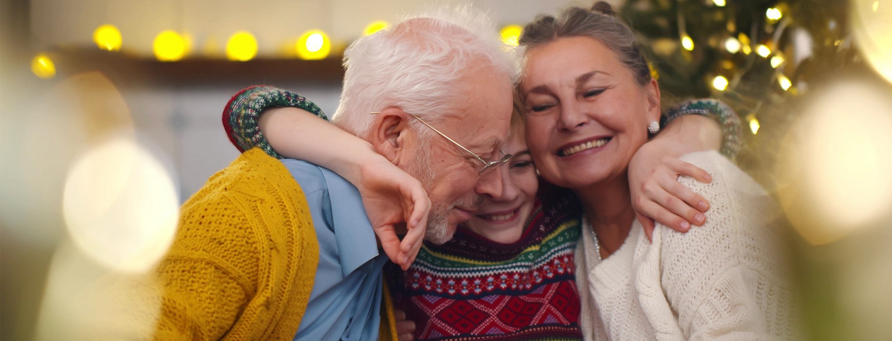 Ein Enkelkind umarmt Oma und Opa